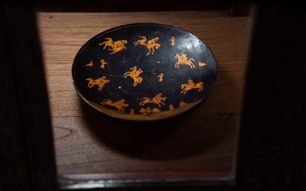 a black and yellow plate with horses on it