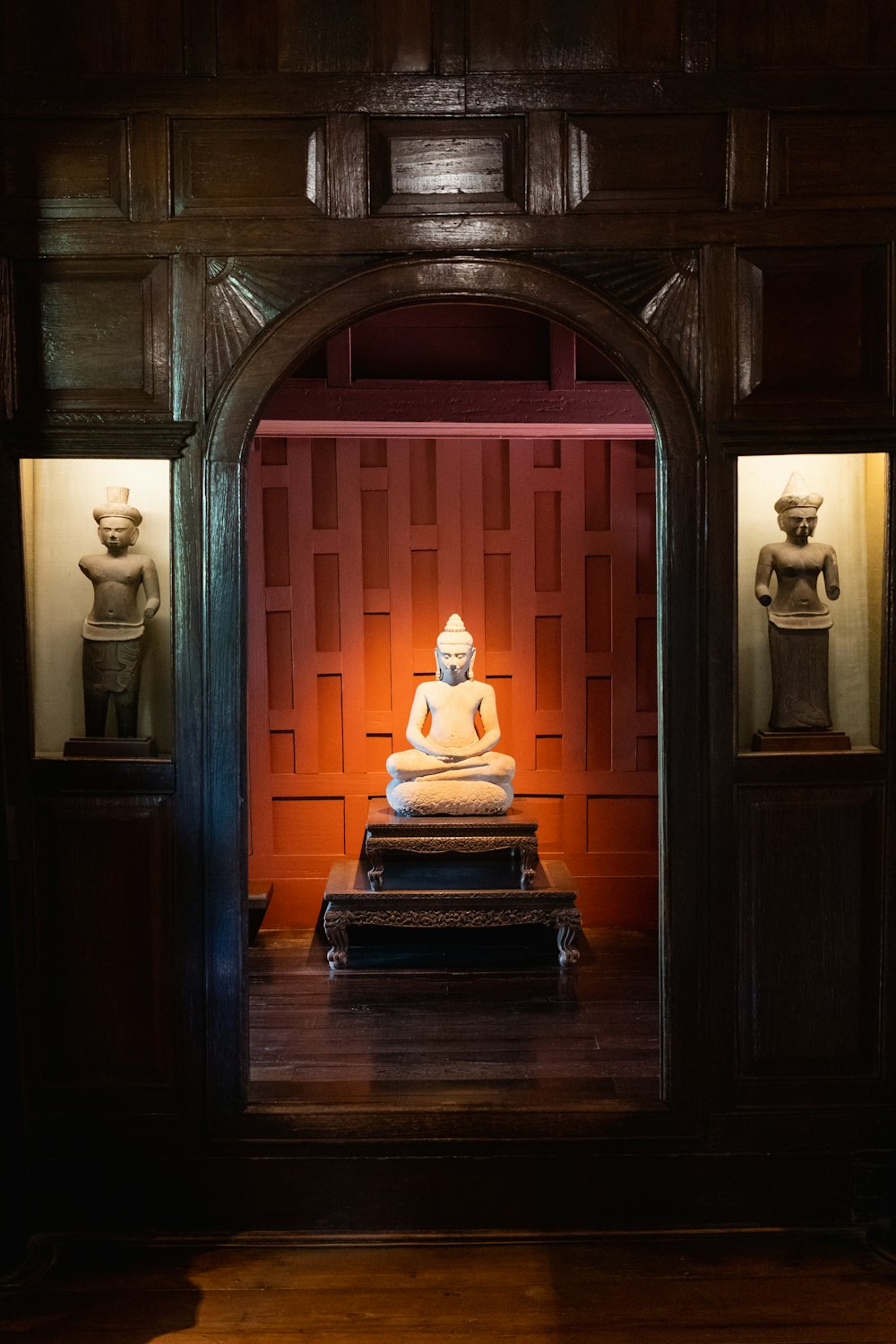 a buddha statue sitting on top of a wooden table