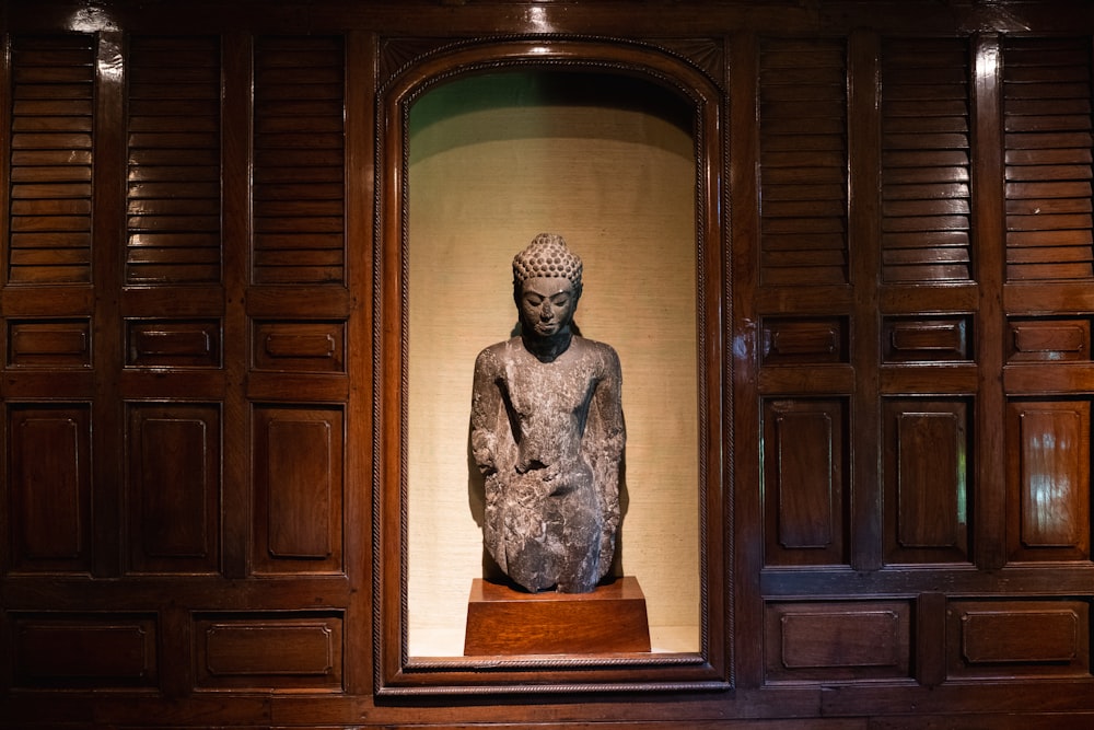 a statue of a seated man in a wooden room