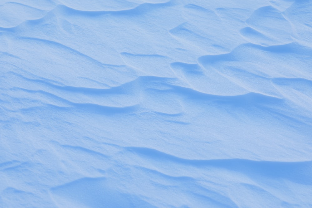 a snowboarder riding down a snow covered slope