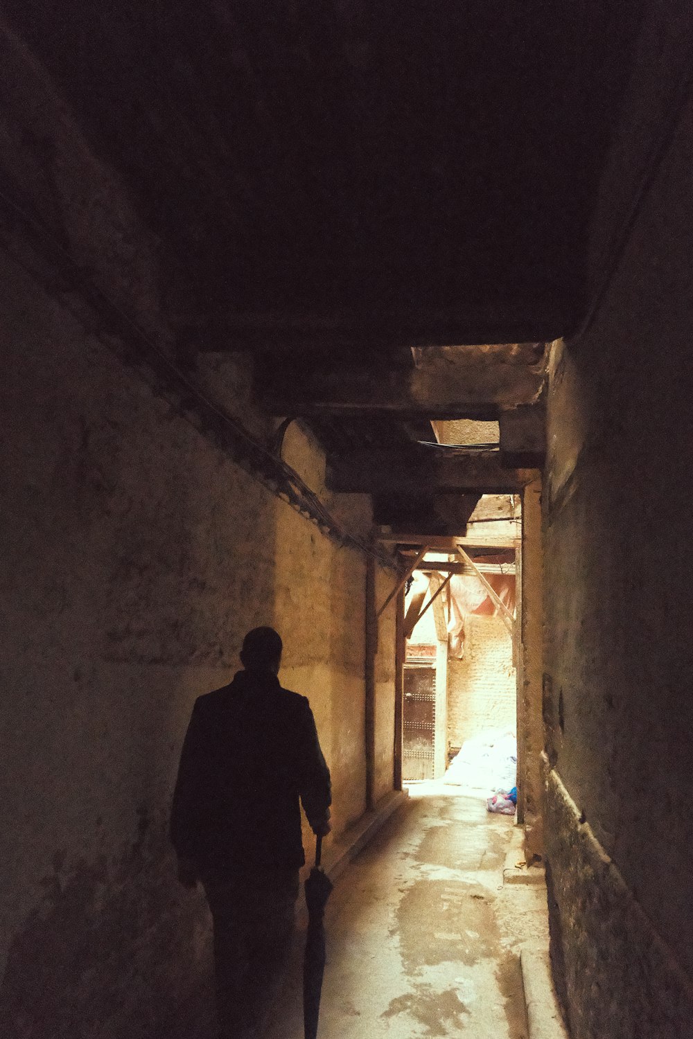 a man walking down a dark alley way