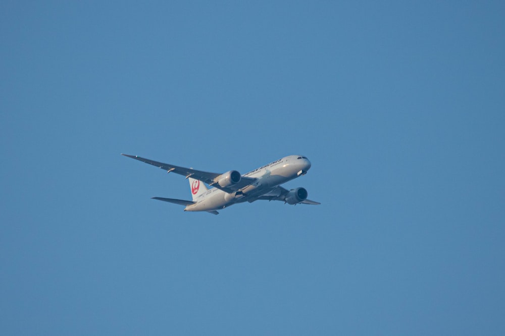 a large jetliner flying through a blue sky