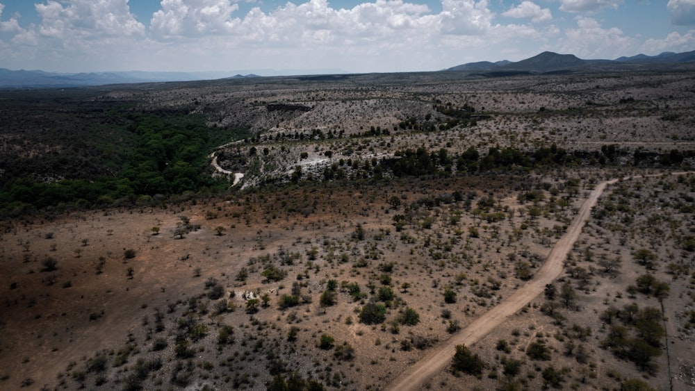 an aerial view of a dirt road in the middle of the desert