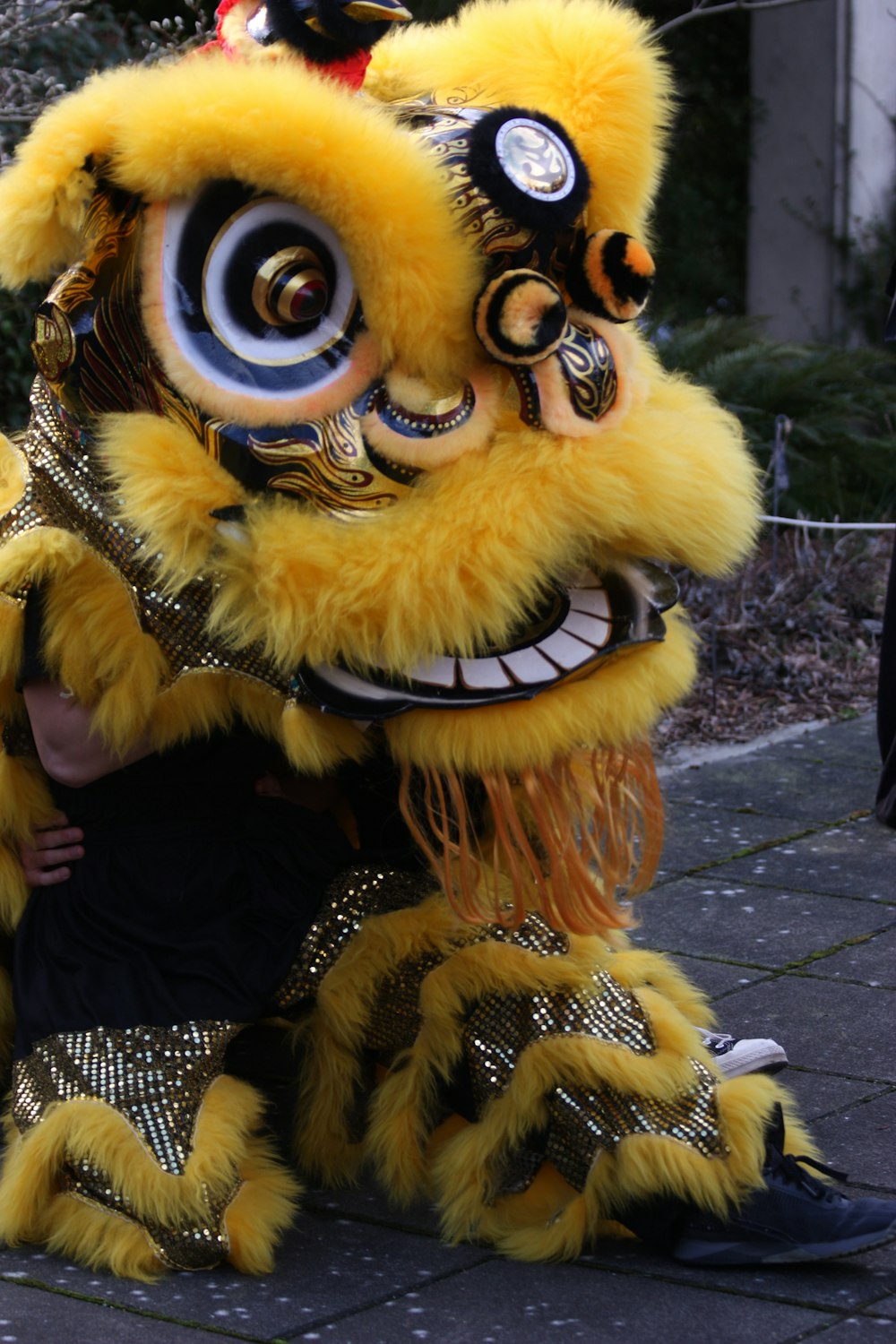 a man sitting on the ground next to a yellow dragon