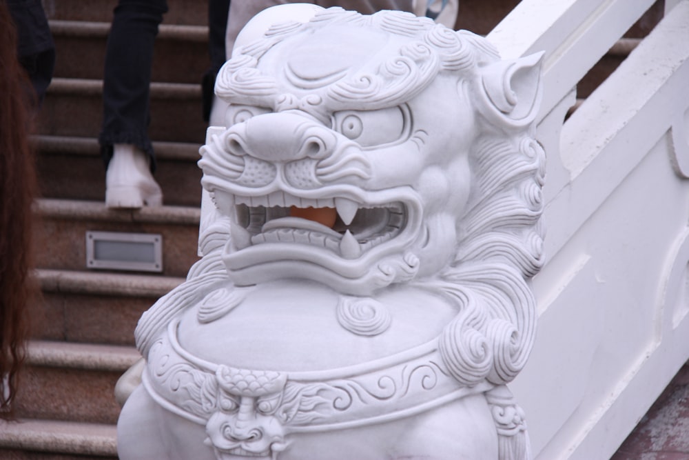 a white lion statue sitting on top of a set of stairs