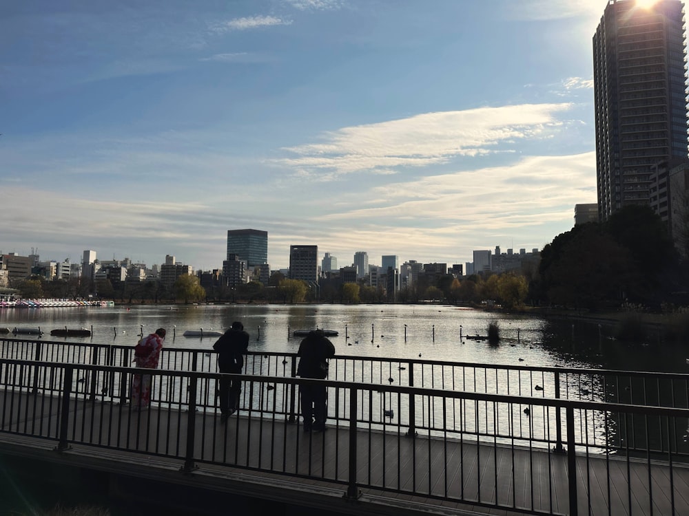 a group of people standing on a bridge over a river