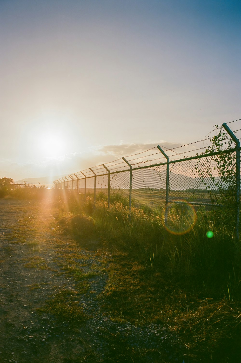 Le soleil se couche derrière une clôture de barbelés