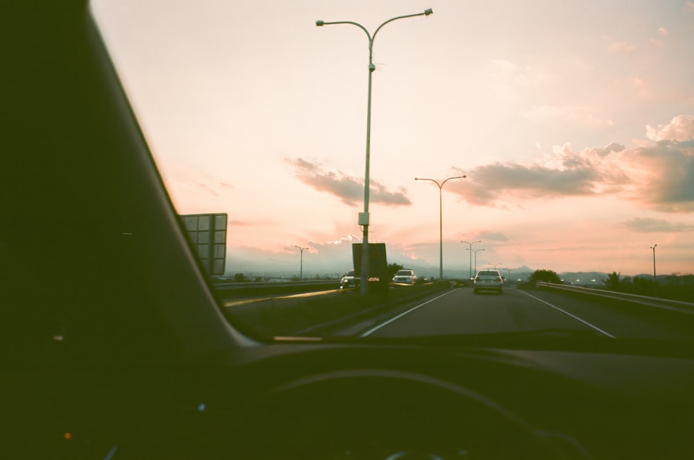 a car driving down a highway next to a traffic light