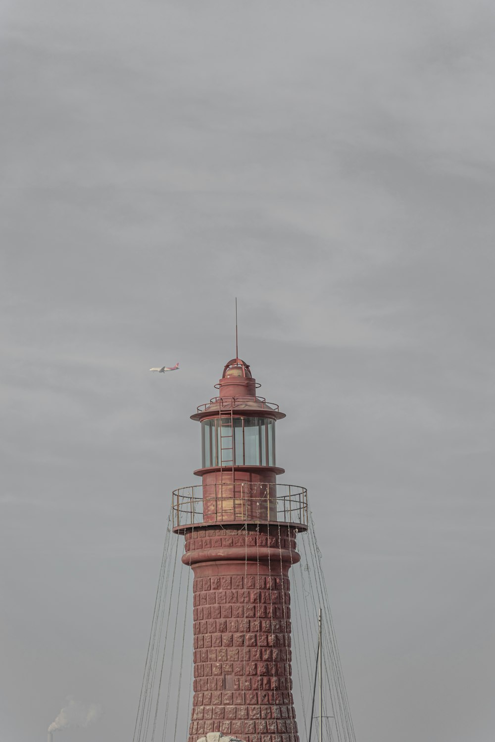 a red and white lighthouse on a cloudy day