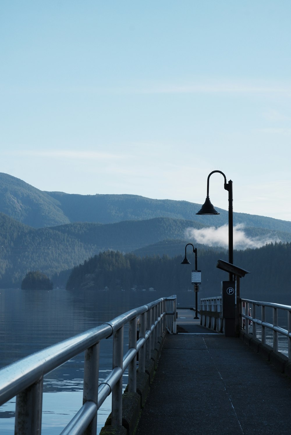 a pier with a lamp post on the end of it