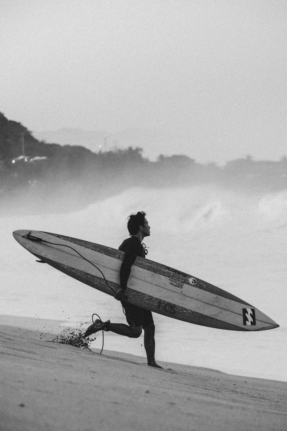 a man carrying a surfboard on top of a beach