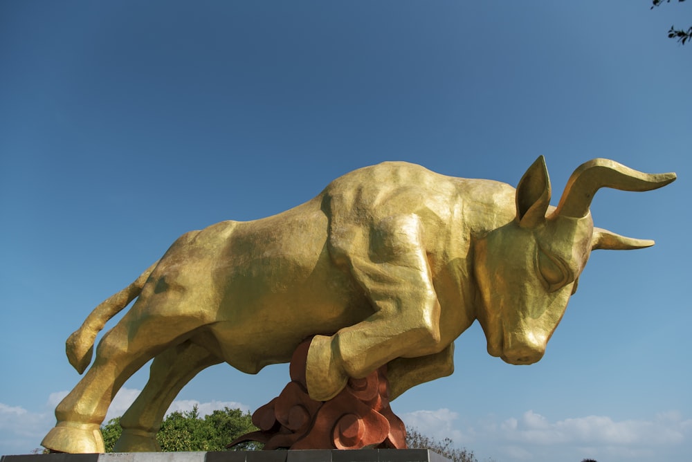 a statue of a bull is shown against a blue sky