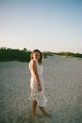 a woman standing in the sand on a beach
