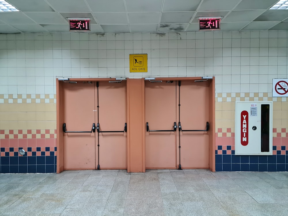 a couple of pink doors sitting inside of a building