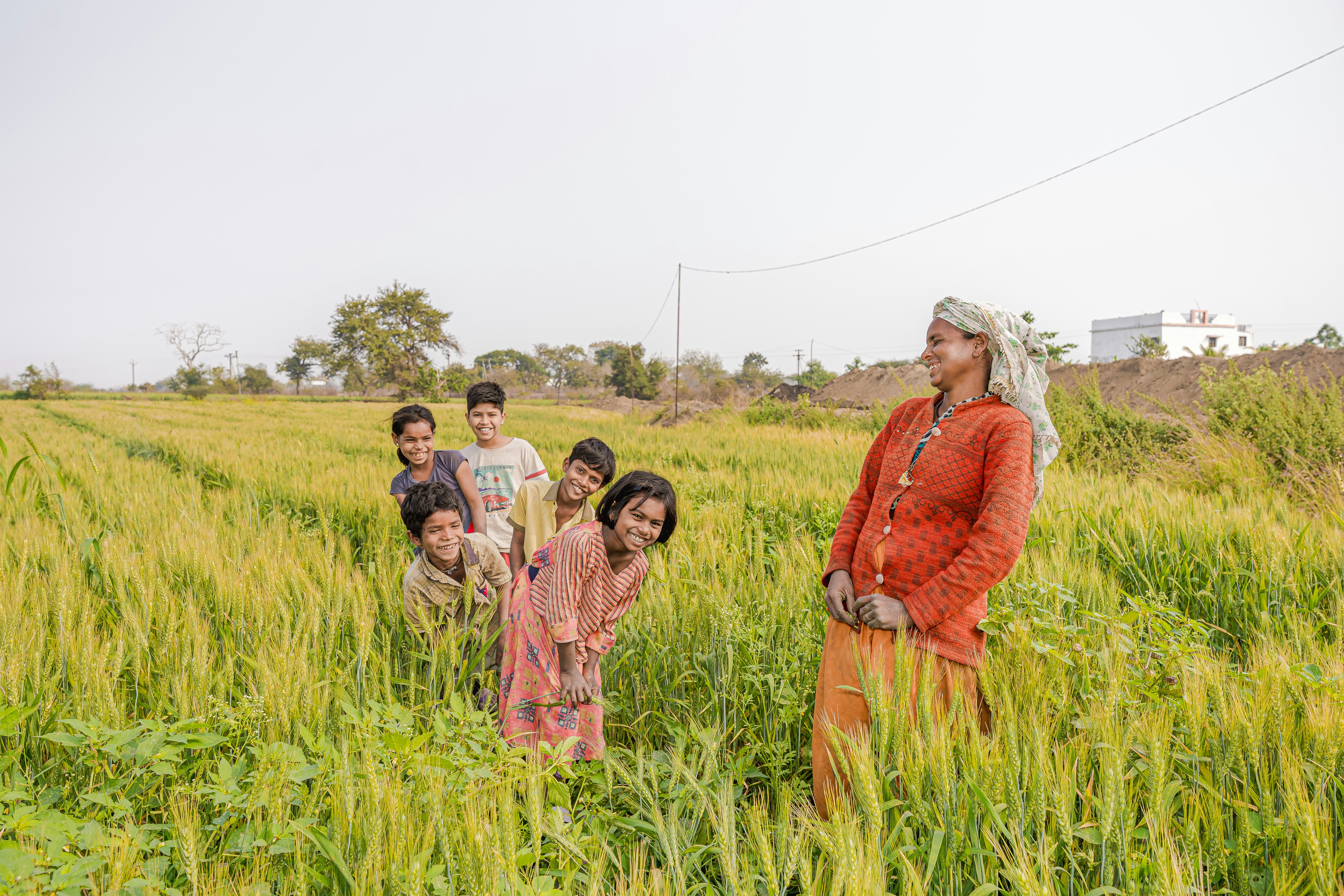 a group of people standing in a field of tall grass