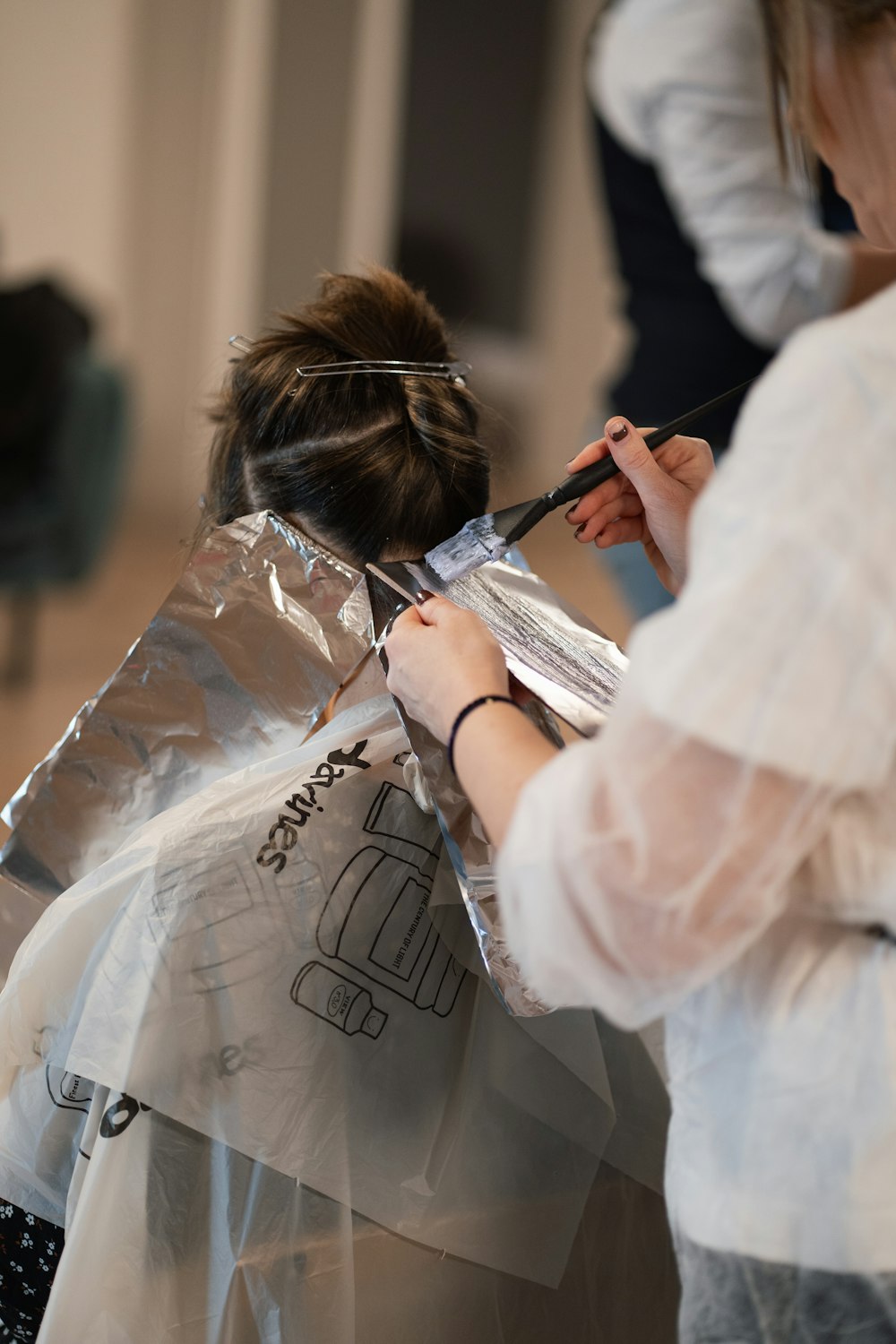 Una mujer se está cortando el pelo con un estilista