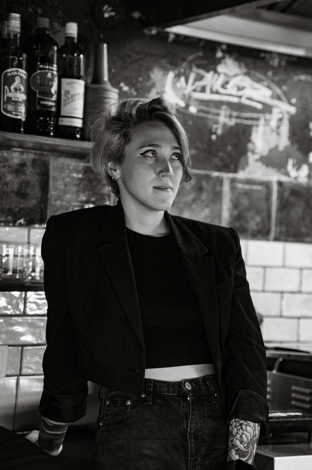 a black and white photo of a woman in a bar