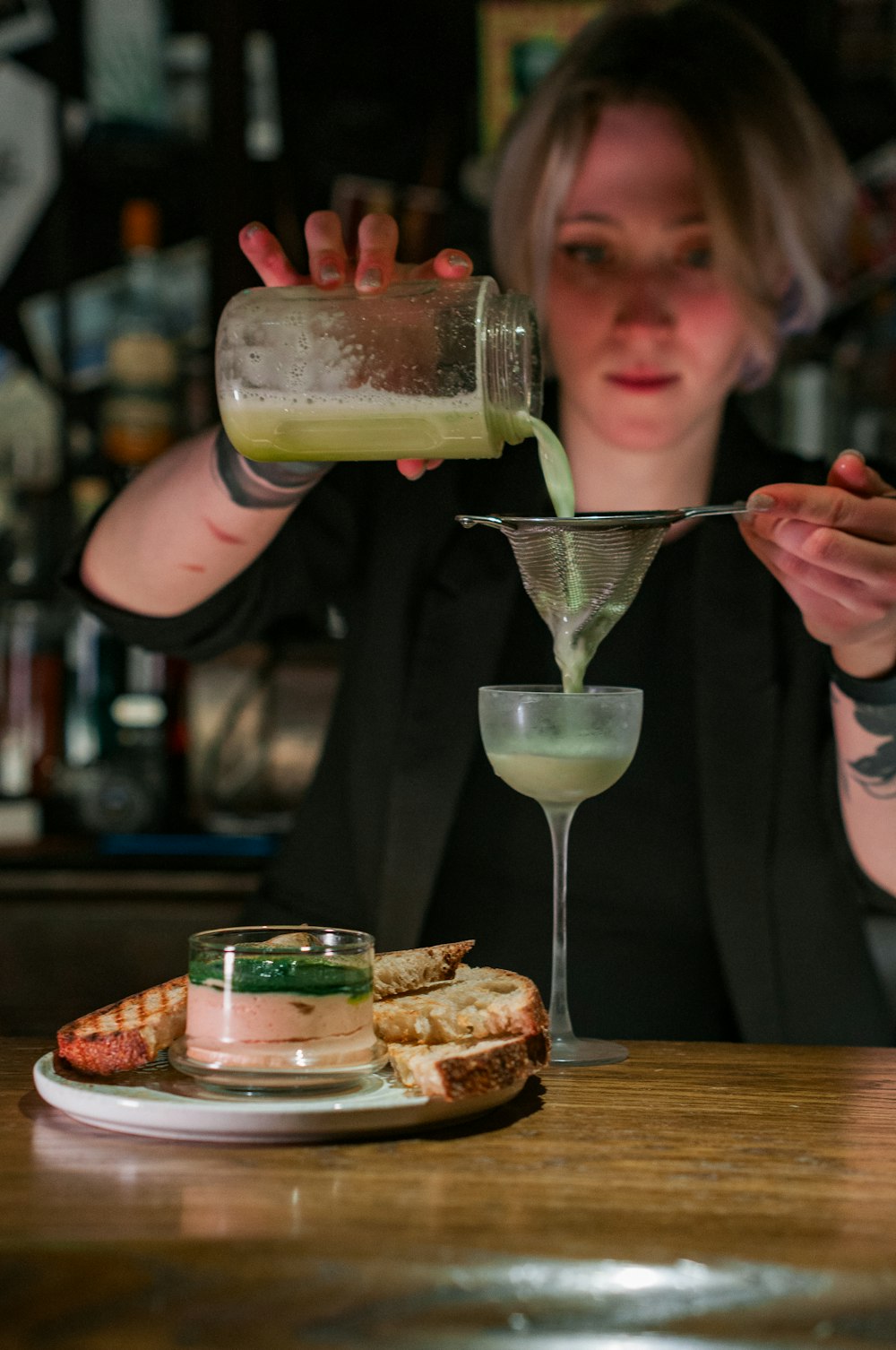 a woman pouring a drink into a glass