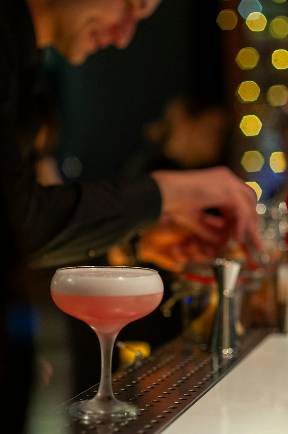 a man is making a drink at a bar