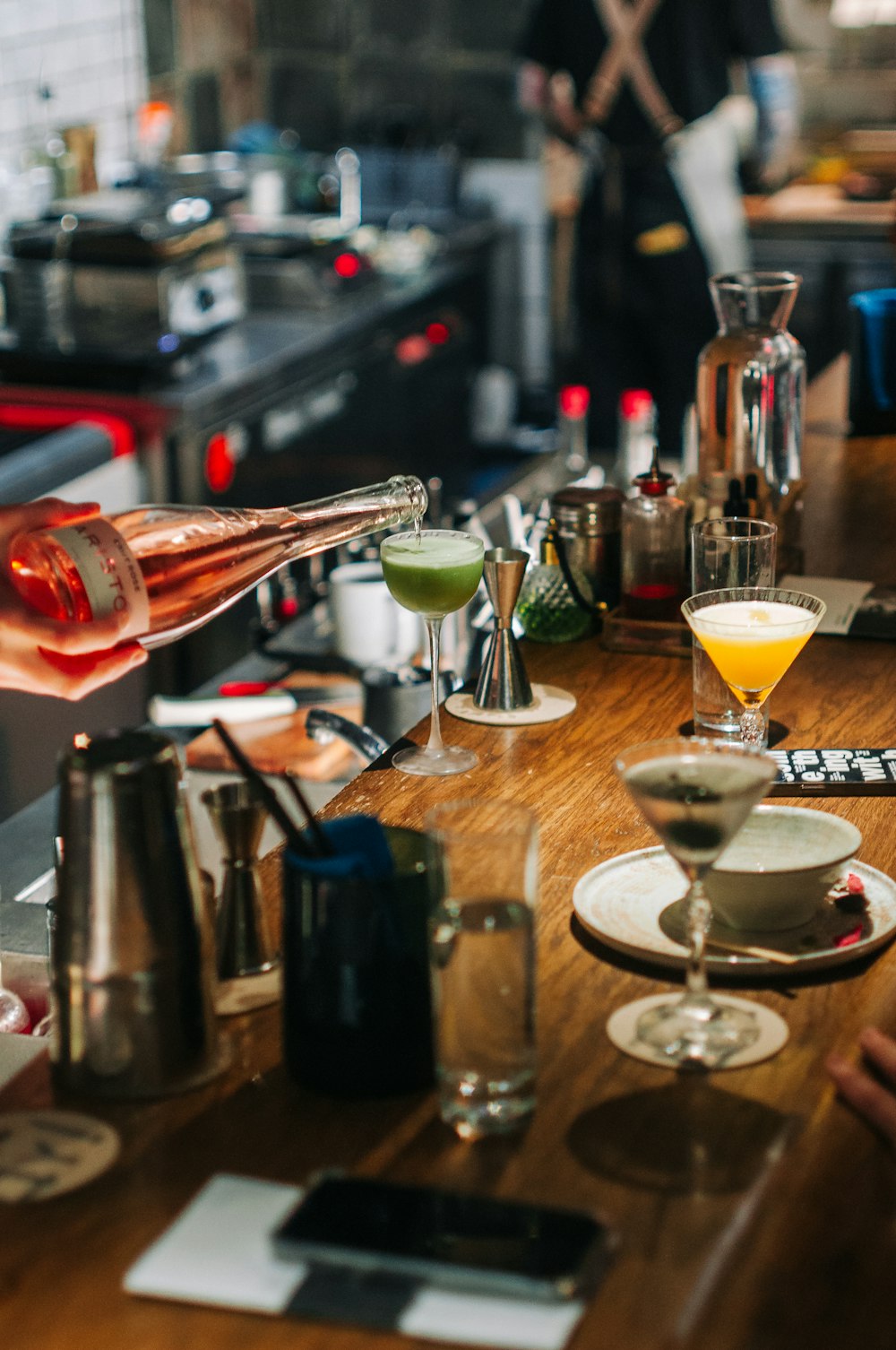 a person pouring a drink into a glass