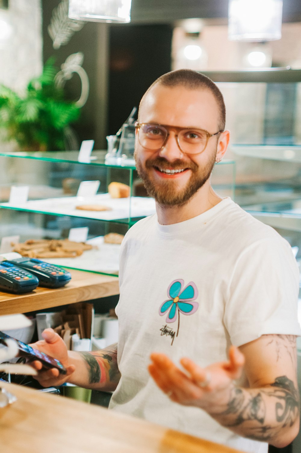 a man with a beard and glasses standing in front of a counter