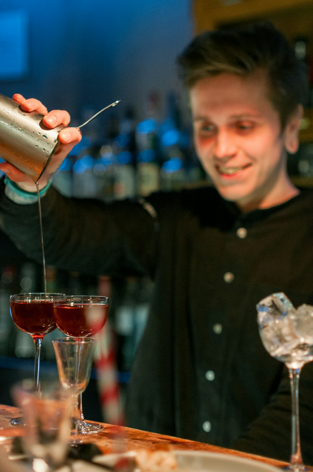 a man pouring a drink into a glass