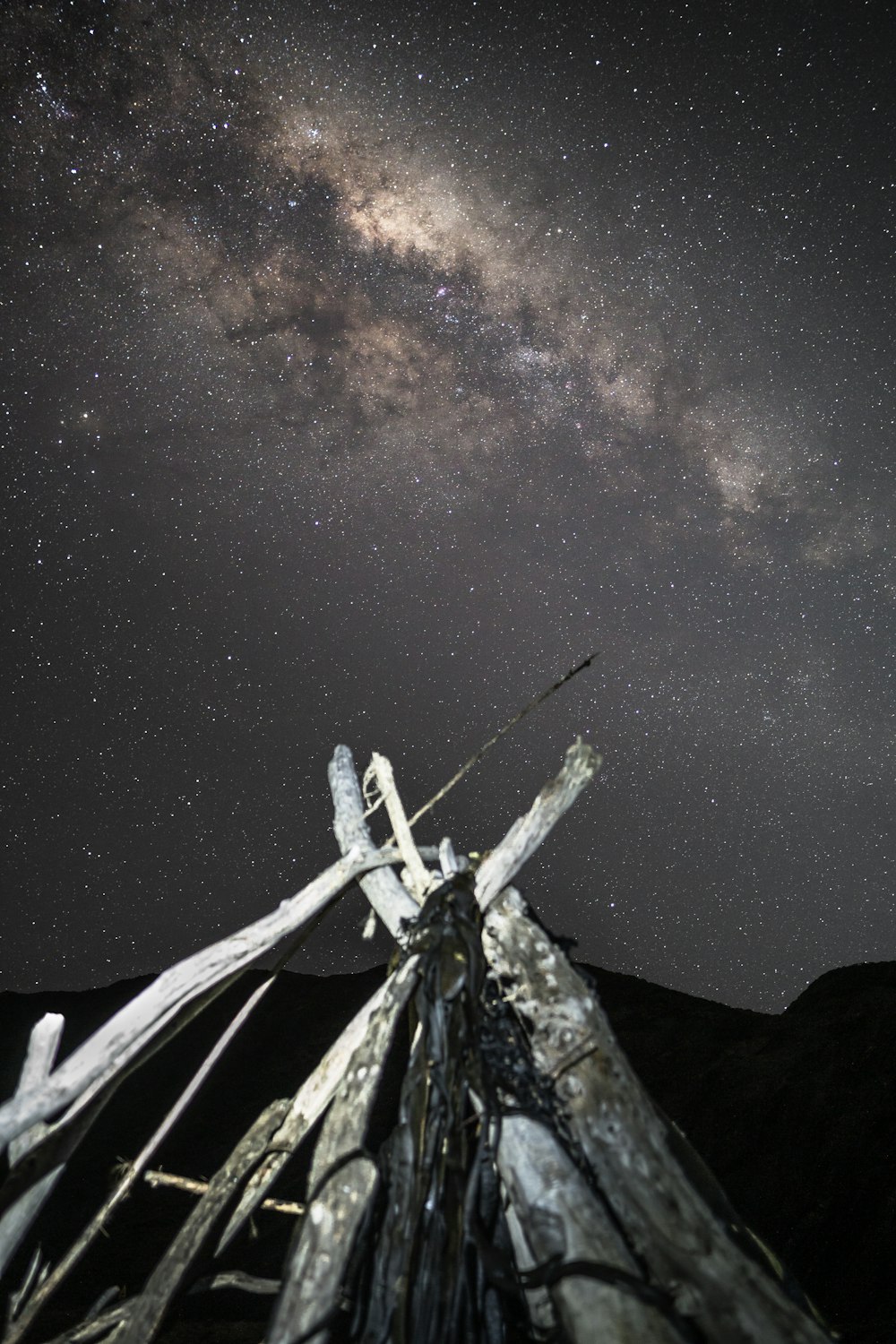 a wooden structure under a night sky filled with stars