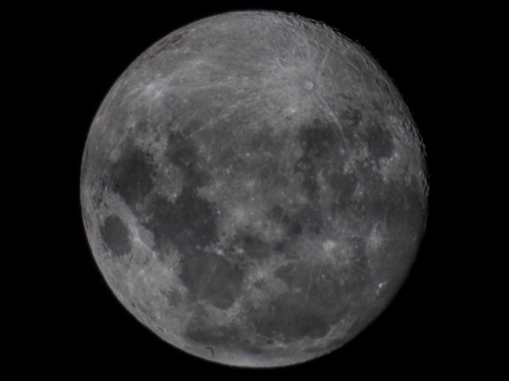 a full moon is seen in the dark sky