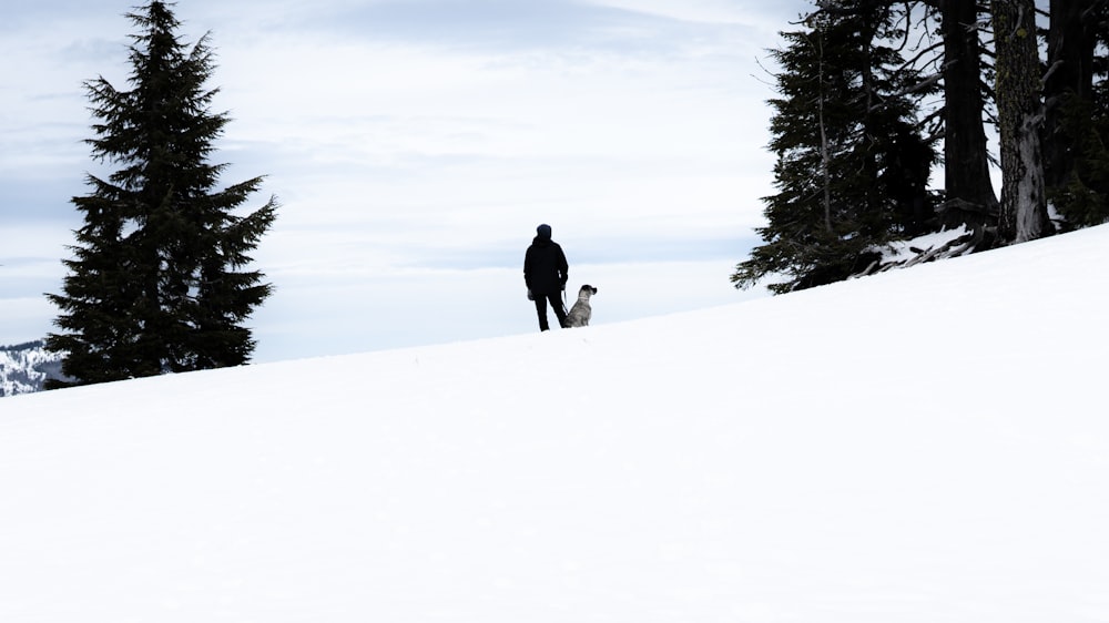 a man standing on top of a snow covered slope