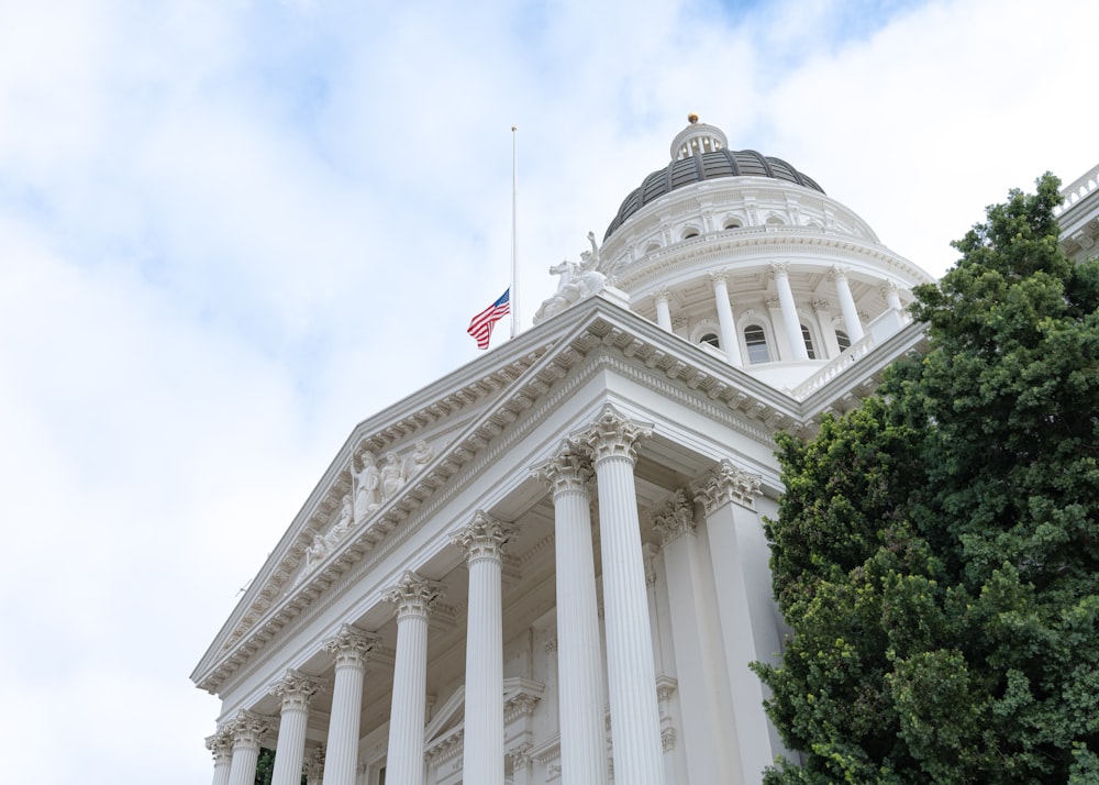 a large white building with columns and a flag on top