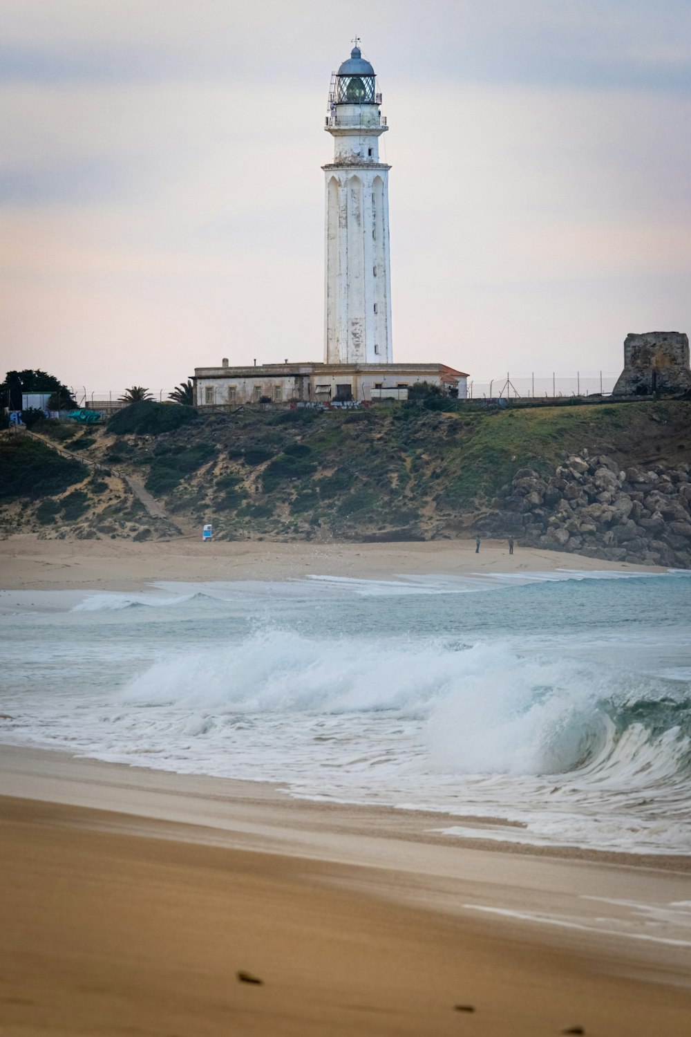 a lighthouse on a hill overlooking the ocean