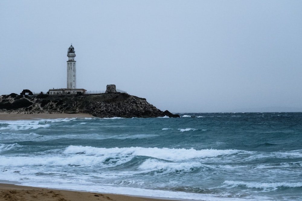 Un phare situé au sommet d’une plage à côté de l’océan