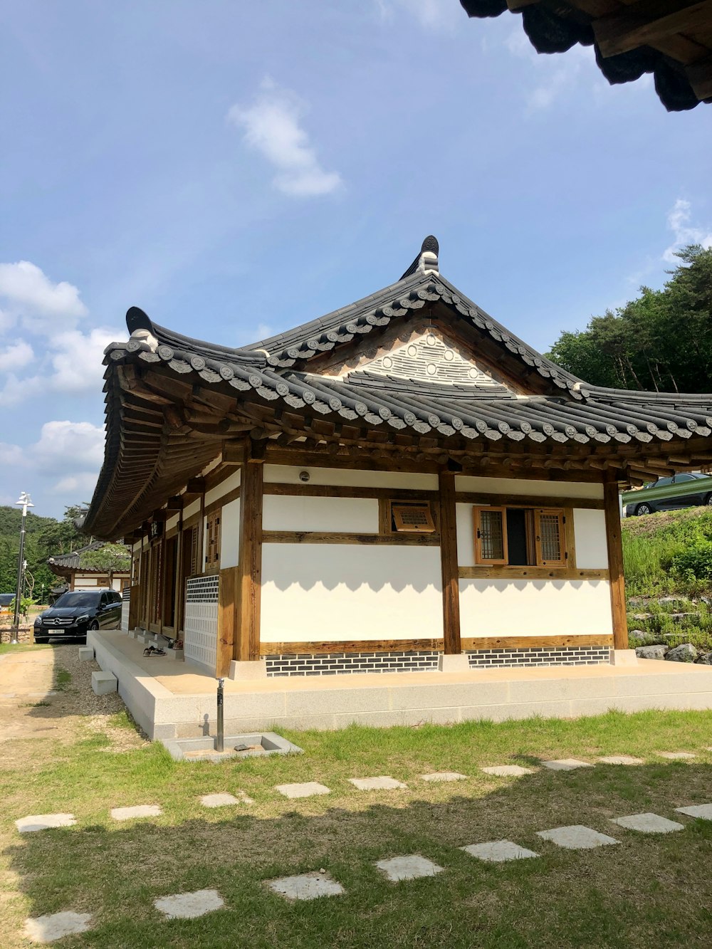 a white and brown building sitting on top of a lush green field