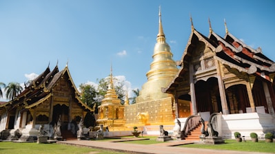 a row of gold and white pagodas in a park