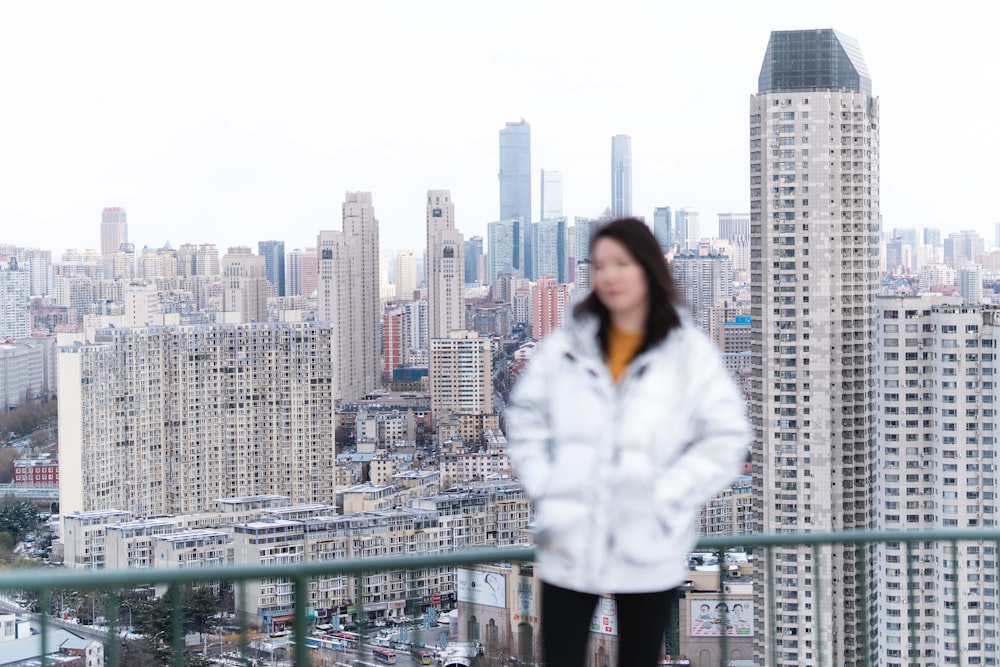 a woman standing on top of a tall building