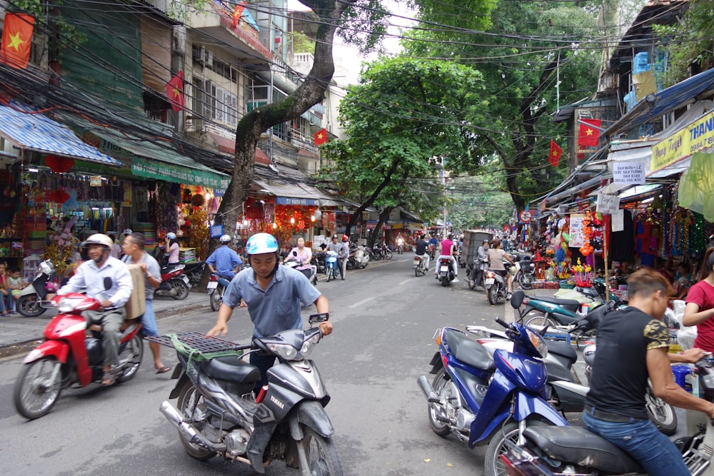 a group of people riding motorcycles down a street