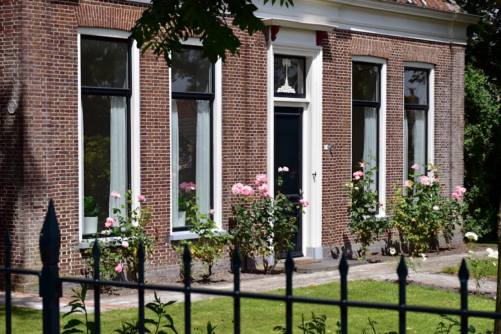 a brick building with many windows and flowers in front of it