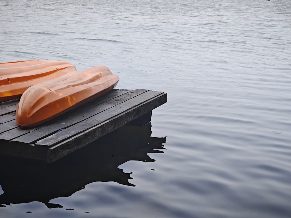 due canoe sono sedute su un molo nell'acqua