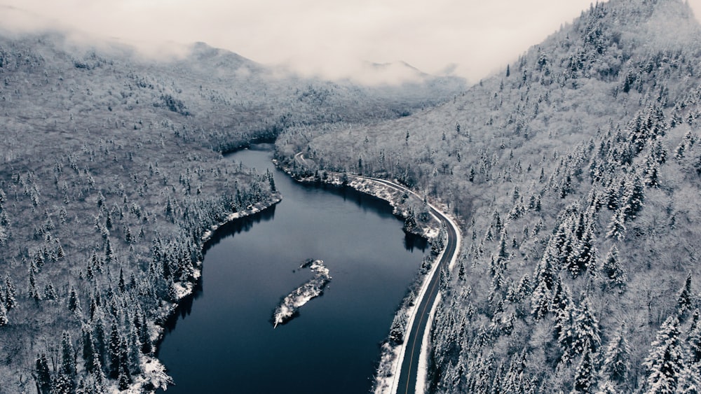 an aerial view of a river surrounded by snow covered mountains