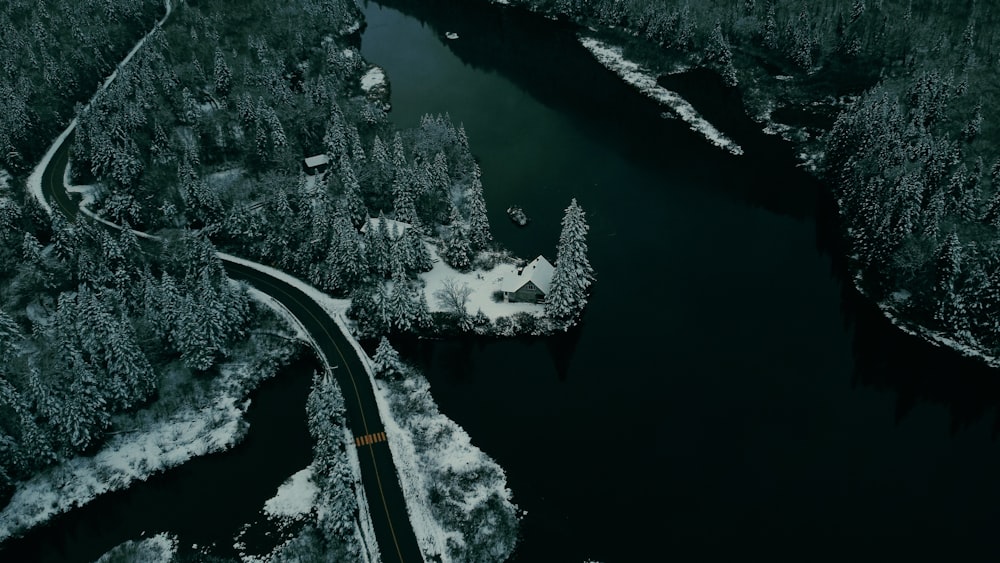 an aerial view of a road in the middle of a snow covered forest