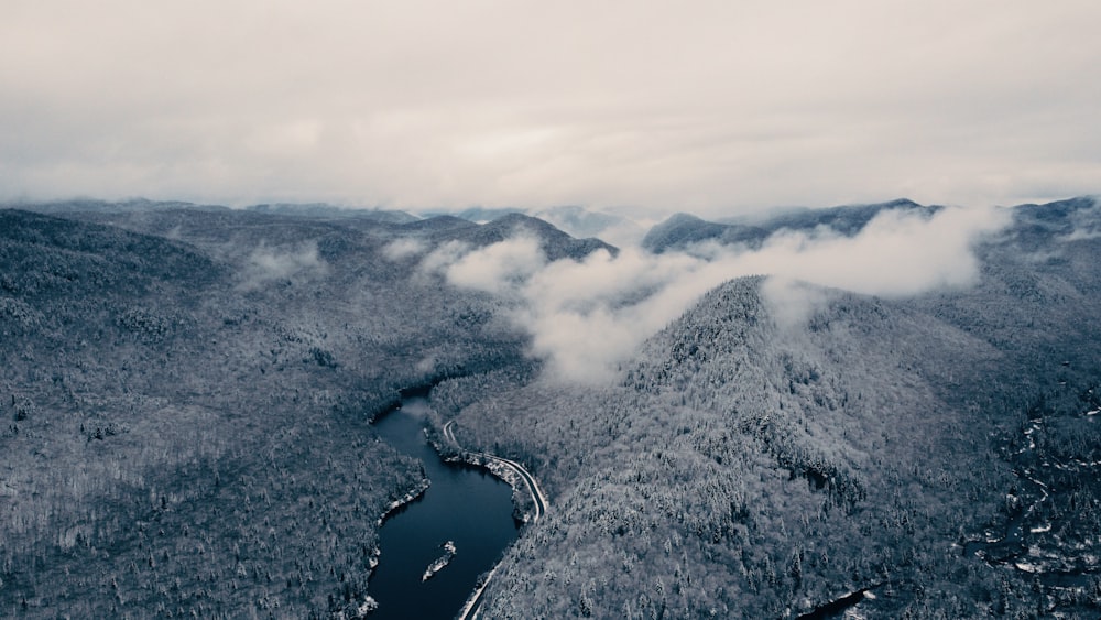 an aerial view of a lake surrounded by mountains