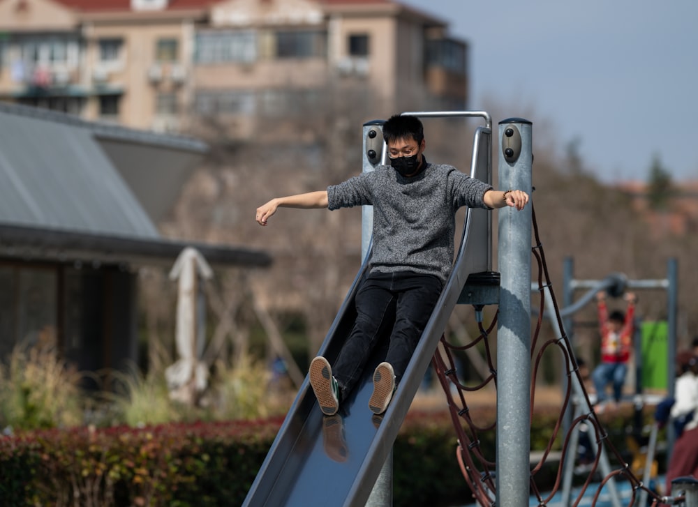 a man in a black mask is on a slide