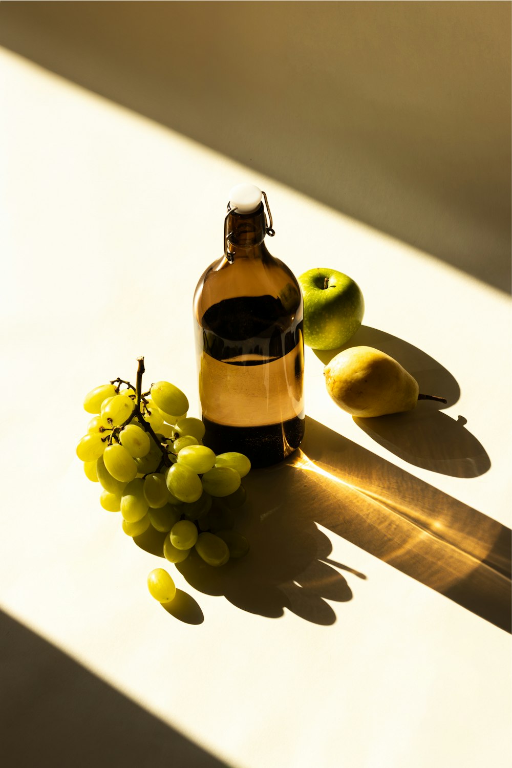 a bottle of wine sitting next to a bunch of grapes