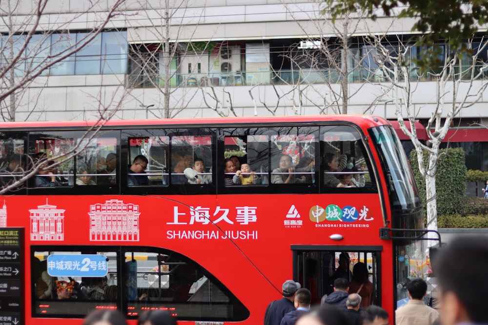 a red double decker bus driving down a street