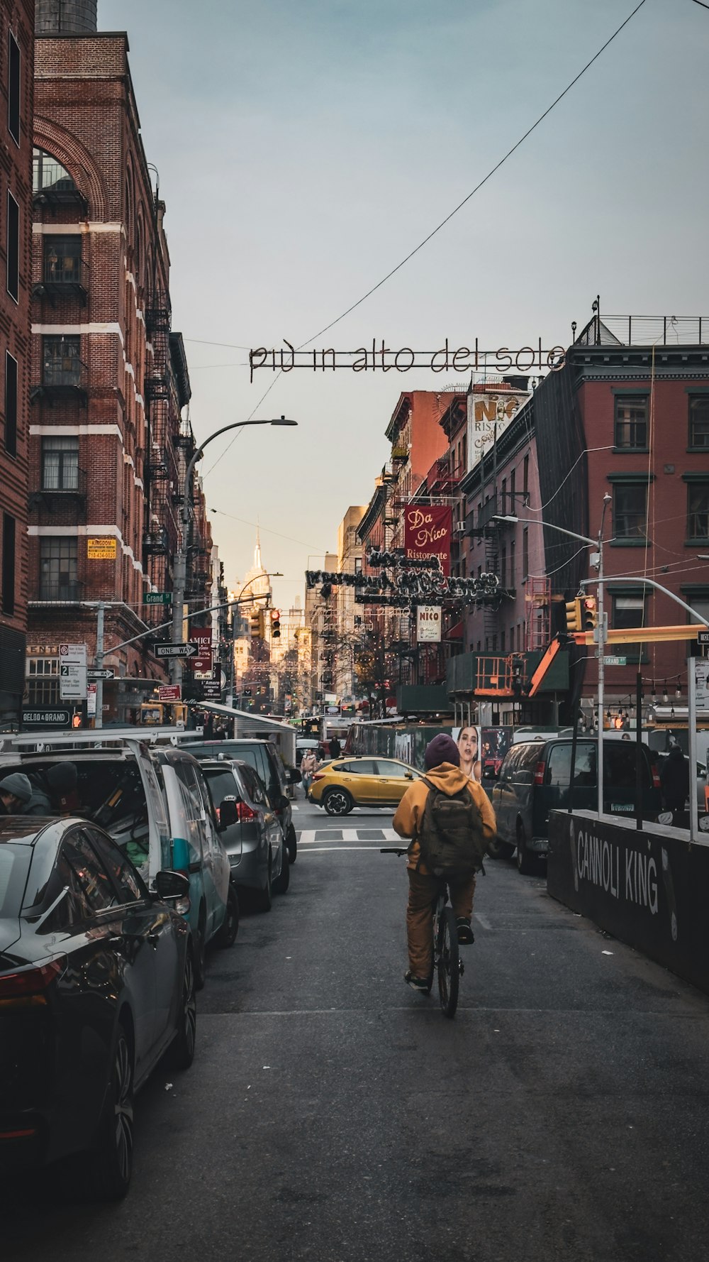 a man riding a bike down a street next to tall buildings