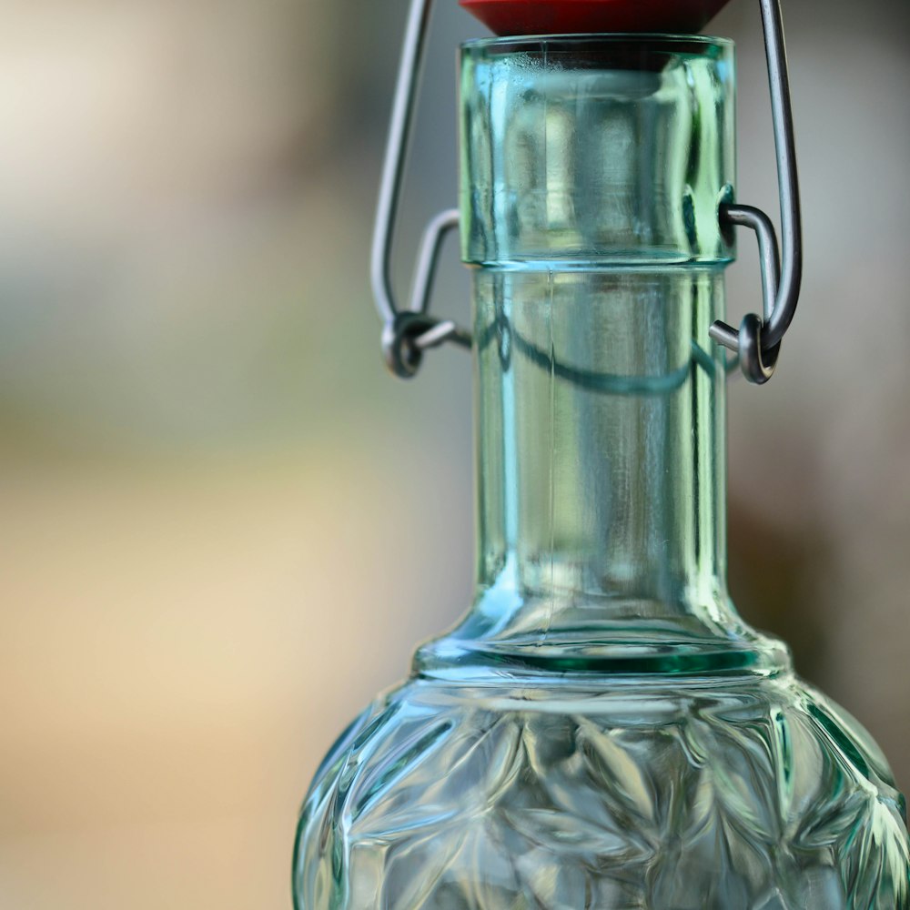 a close up of a glass bottle with a red cap