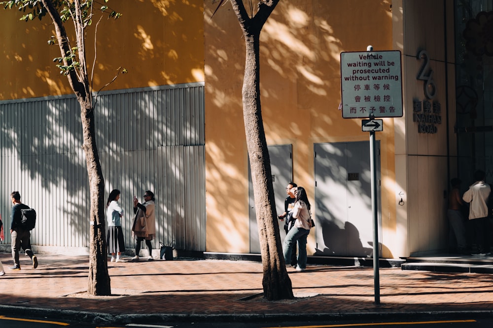 a group of people walking down a street next to a tall building