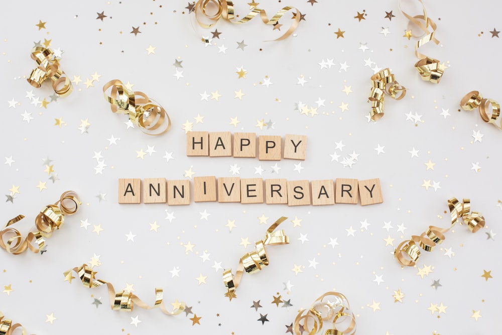 a happy anniversary spelled with scrabbles on a white background