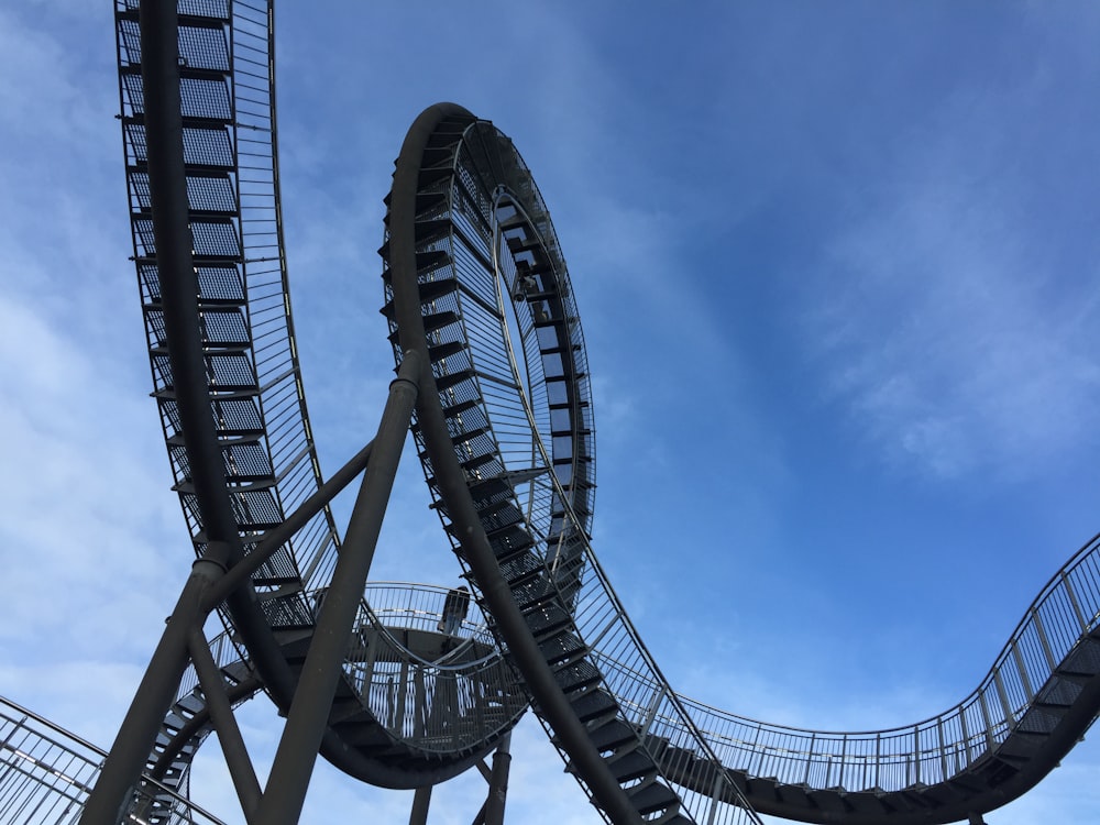 a roller coaster going through a blue sky