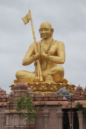 a golden statue of a person holding a flag